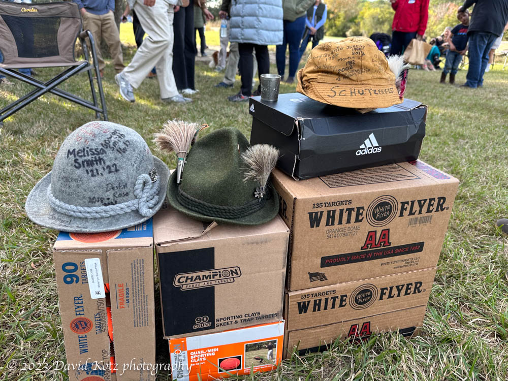 three felt hats, sitting on boxes of skeet (clay discs) and shotgun shells.